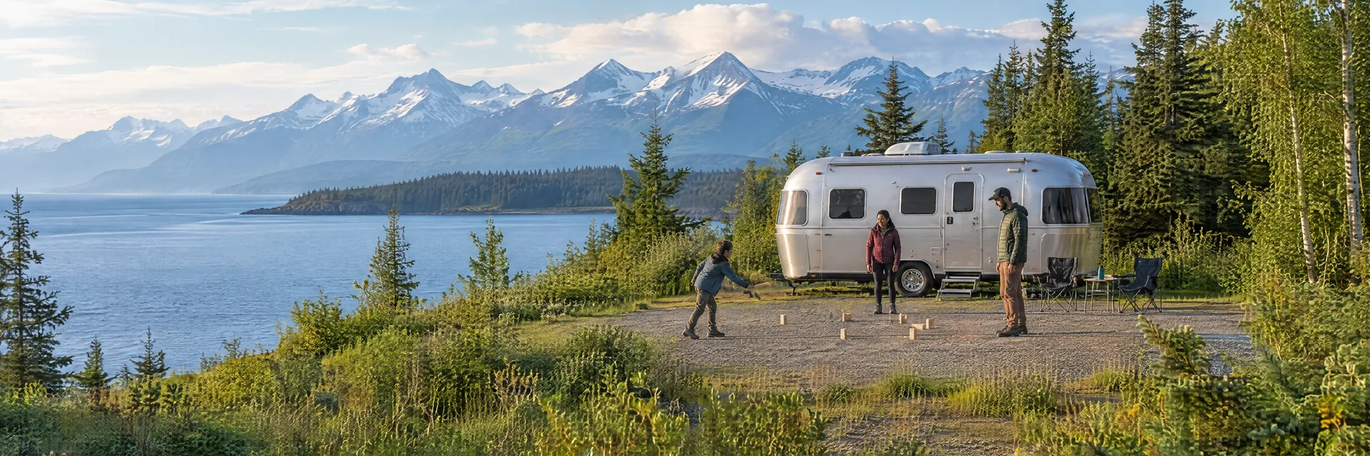 Illustration of campers enjoying family campsite activities beside a rounded silver travel trailer in a fictional camping setting inspired by Anchorage, AK.