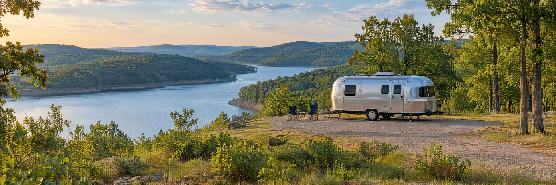 Illustration of a rounded silver travel trailer at a fictional camping setting inspired by Clinton, AR.