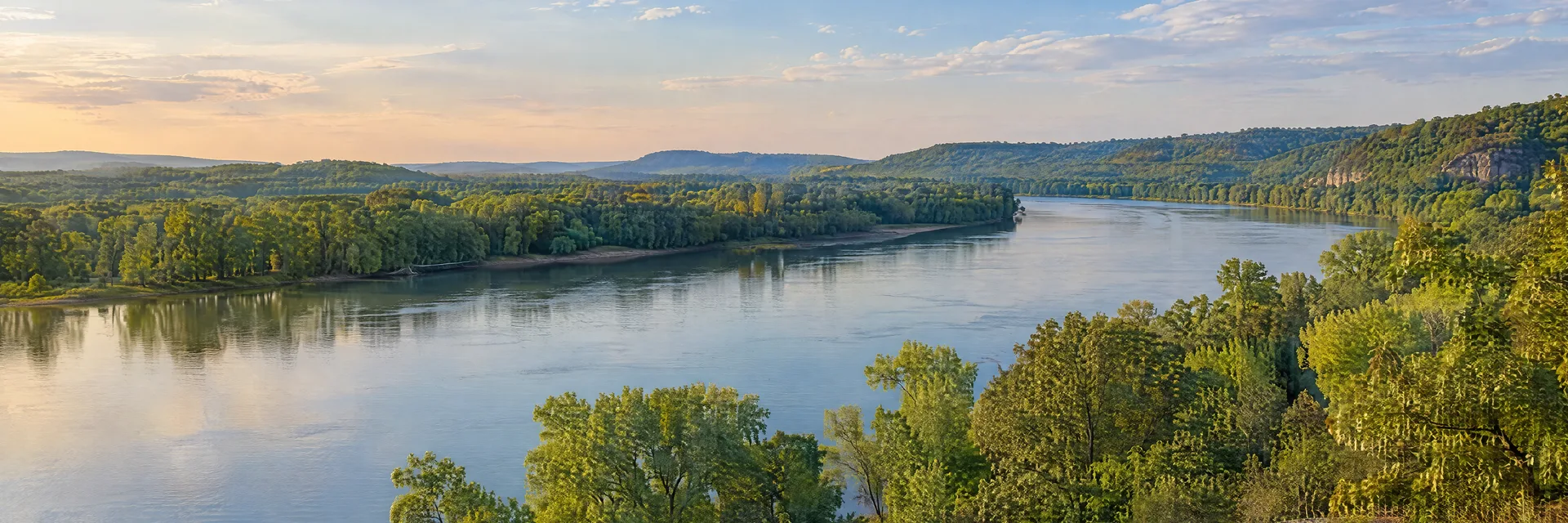 Illustration inspired by North Little Rock, AR: central Arkansas river country, broad slow river, cottonwood and hardwood groves and softly rolling wooded hills.