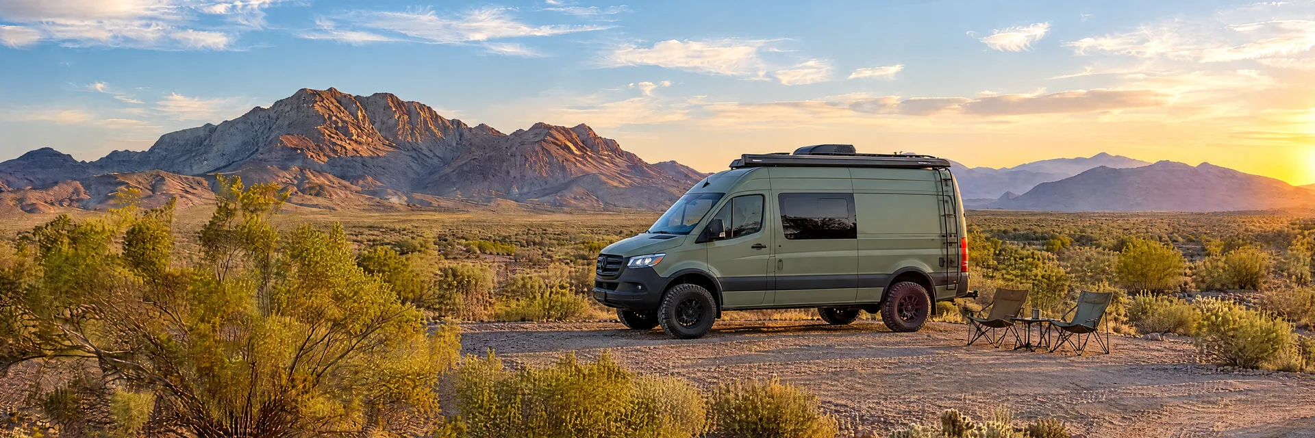 Illustration of a sage-green modern campervan at a fictional camping setting inspired by Quartzsite, AZ.