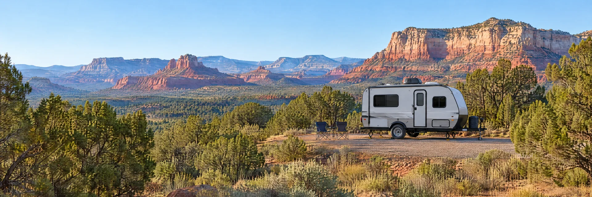Illustration of a compact travel trailer at a fictional camping setting inspired by Sedona, AZ.
