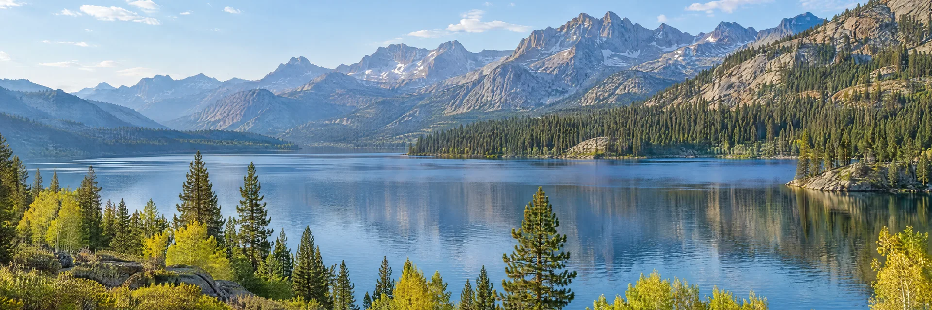 Illustration inspired by June Lake, CA: eastern Sierra mountain lake with pine groves, aspens and distant rugged granite ridges.