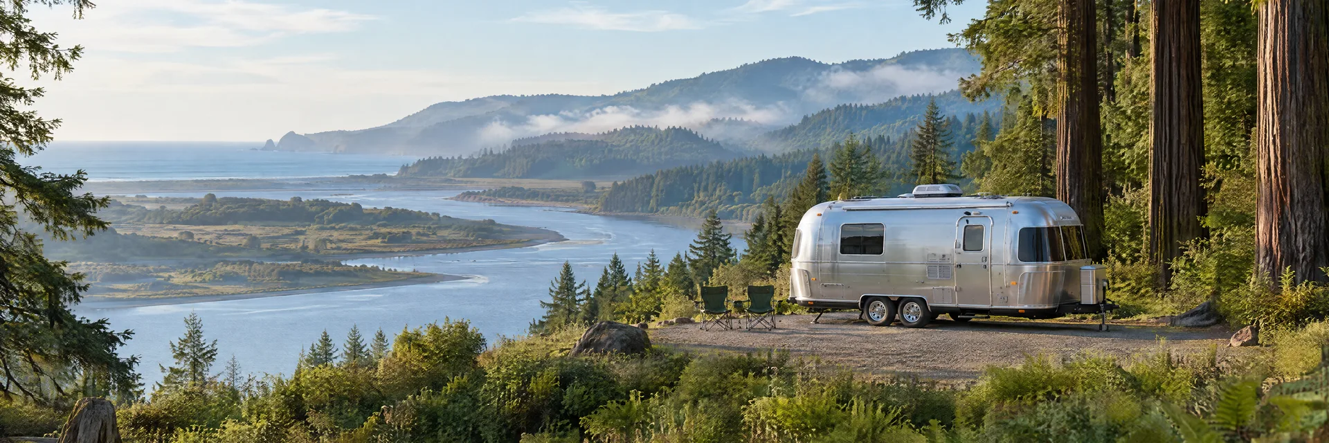 Illustration of a rounded silver travel trailer at a fictional camping setting inspired by Klamath, CA.