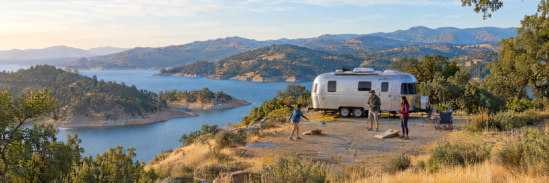 Illustration of campers enjoying family campsite activities beside a rounded silver travel trailer in a fictional camping setting inspired by Lake Don Pedro, CA.