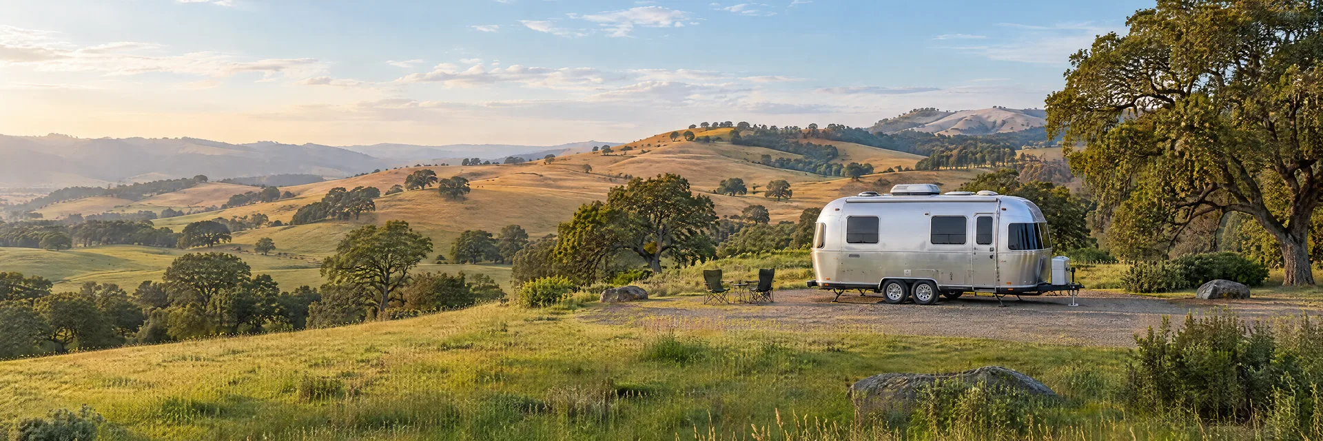 Illustration of a rounded silver travel trailer at a fictional camping setting inspired by Petaluma, CA.