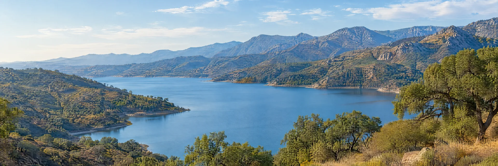 Illustration inspired by San Dimas, CA: southern California San Gabriel foothills, blue reservoir, dry chaparral slopes, scattered live oaks and rugged mountain ridges.