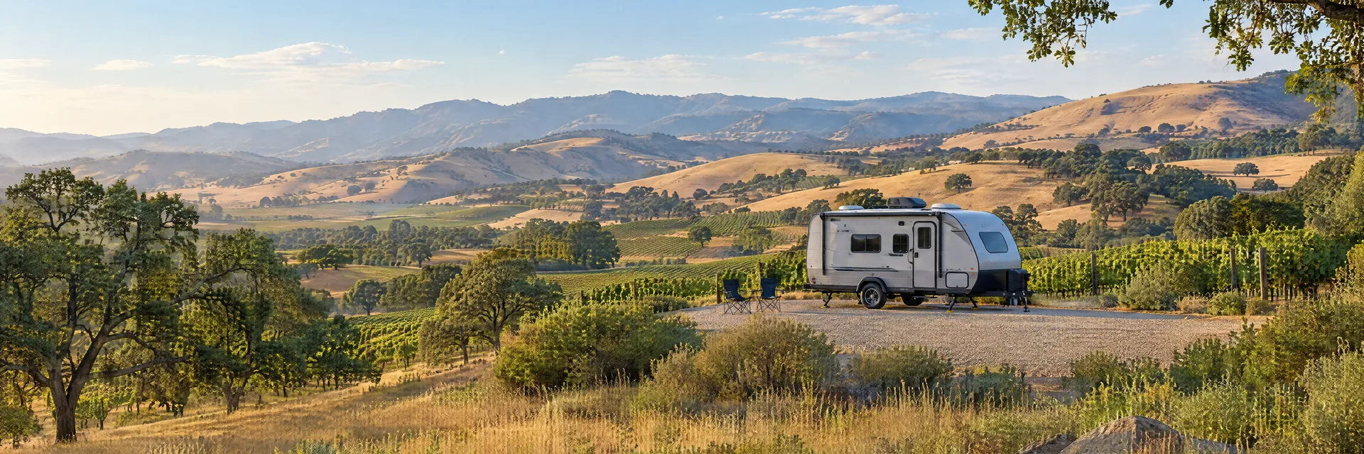 Illustration of a compact travel trailer at a fictional camping setting inspired by Solvang, CA.