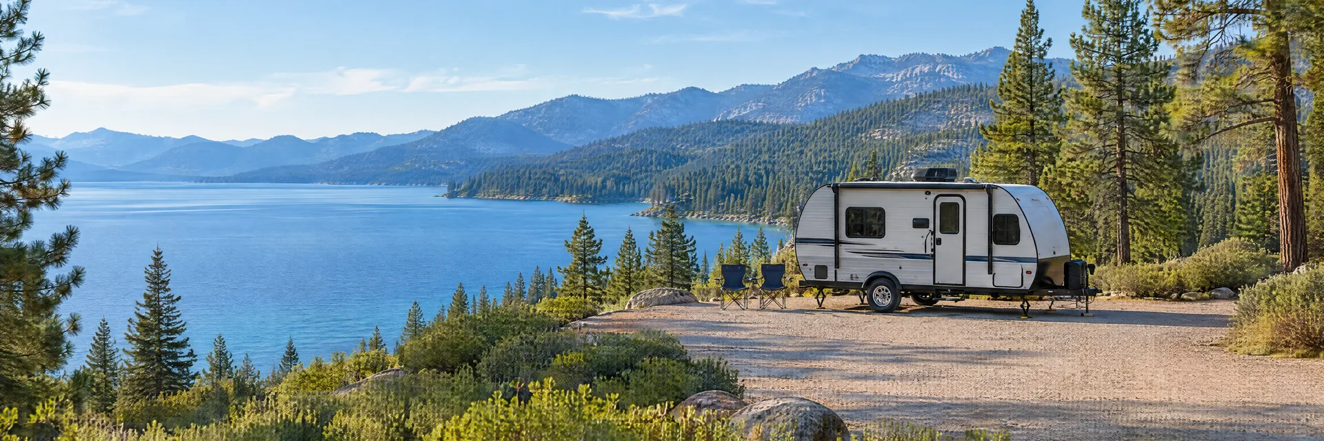 Illustration of a compact travel trailer at a fictional camping setting inspired by Tahoe City, CA.