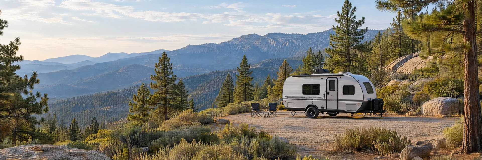 Illustration of a compact travel trailer at a fictional camping setting inspired by Wrightwood, CA.