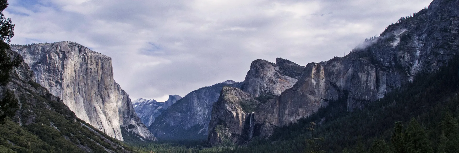 Yosemite Valley seen from Tunnel View, with granite cliffs above conifer forest.
