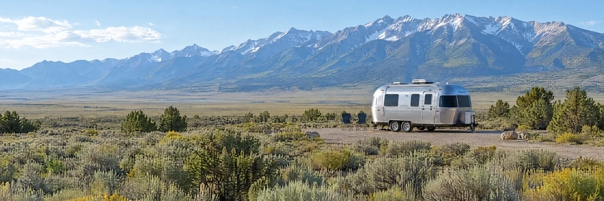 Illustration of a rounded silver travel trailer at a fictional camping setting inspired by Blanca, CO.