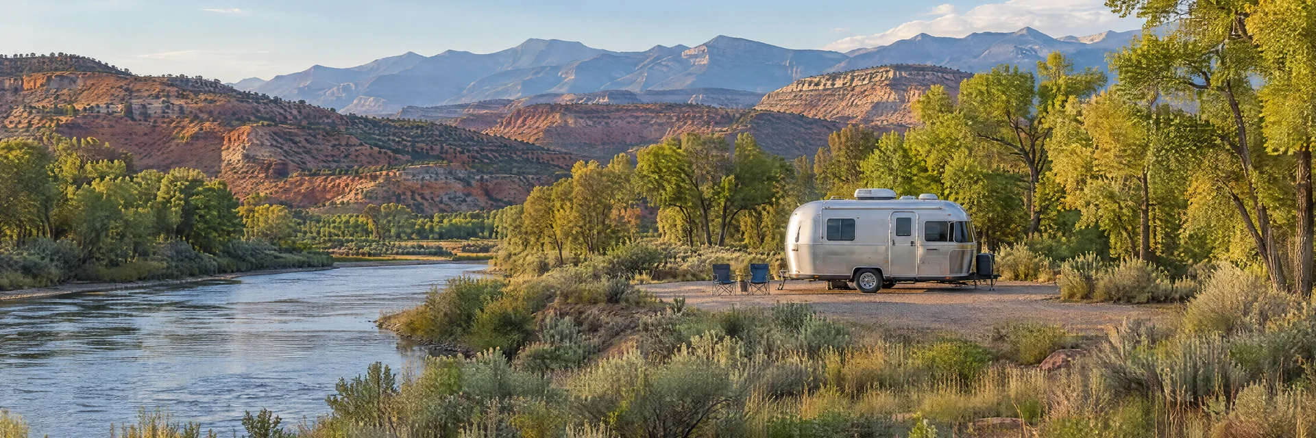 Illustration of a rounded silver travel trailer at a fictional camping setting inspired by Dolores, CO.