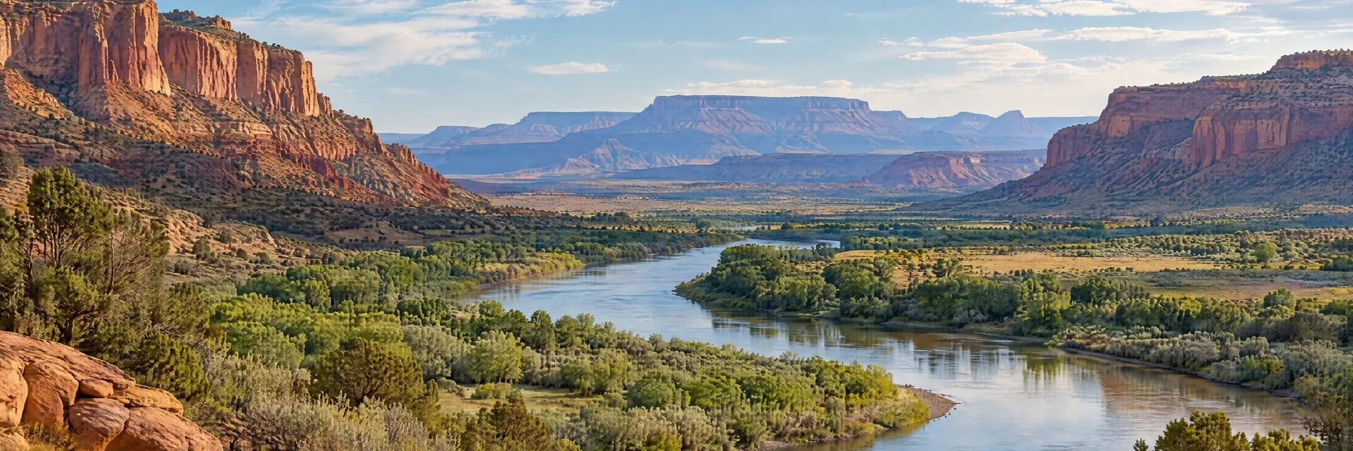 Illustration inspired by Grand Junction, CO: western Colorado desert river valley with red cliffs and distant mesas.