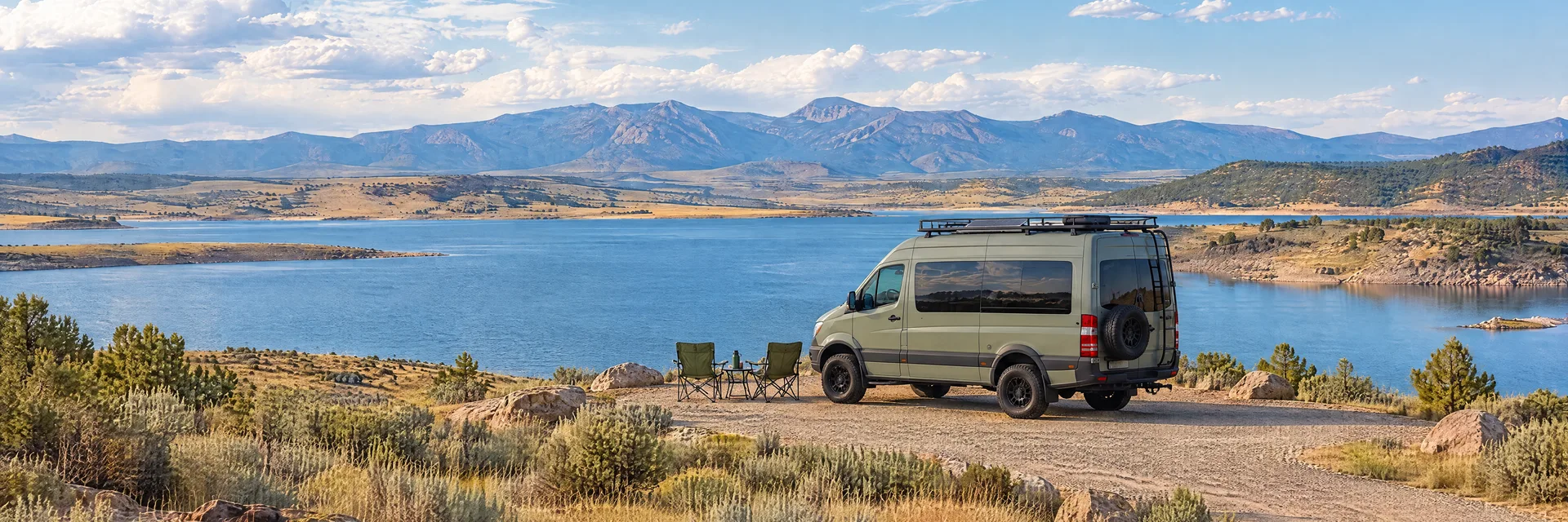 Illustration of a sage-green modern campervan at a fictional camping setting inspired by Pueblo, CO.