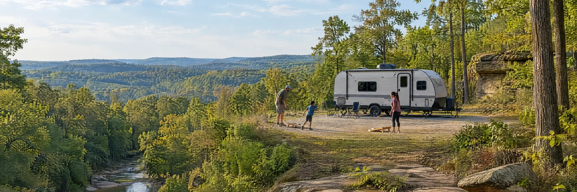 Illustration of campers enjoying family campsite activities beside a compact travel trailer in a fictional camping setting inspired by Stonefort, IL.