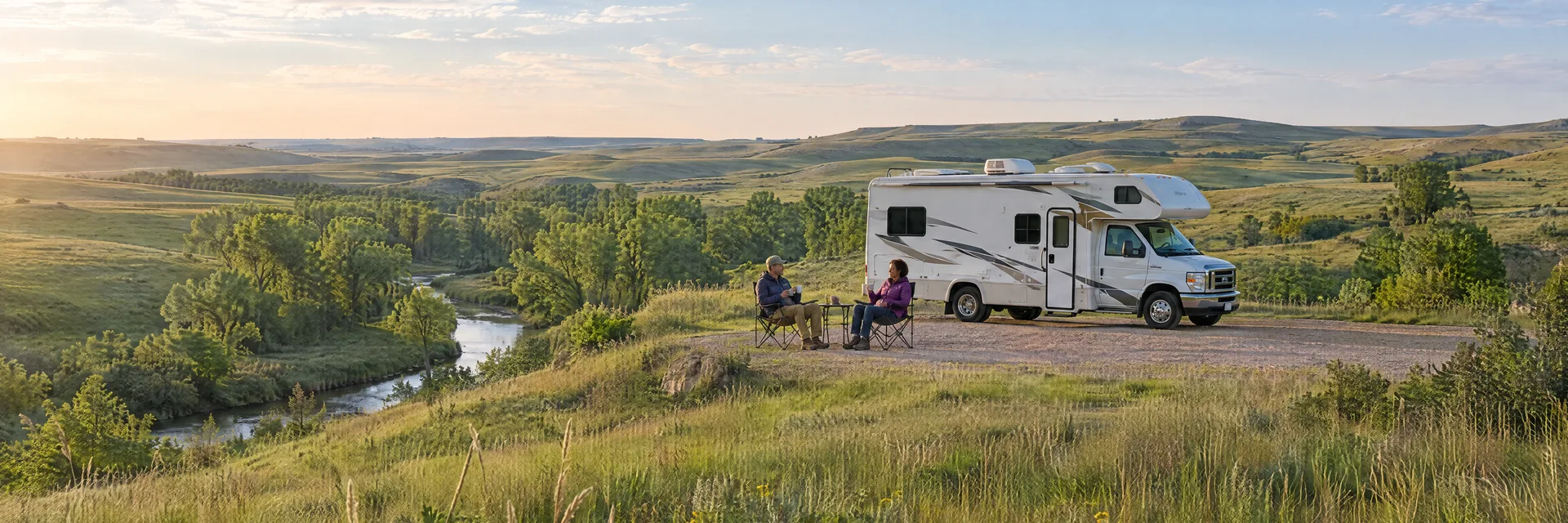 Illustration of campers enjoying morning coffee beside a Class C motorhome in a fictional camping setting inspired by Manhattan, KS.