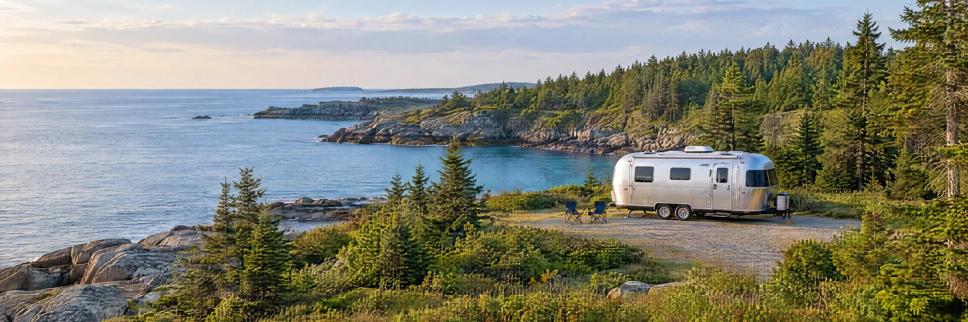 Illustration of a rounded silver travel trailer at a fictional camping setting inspired by Portland, ME.