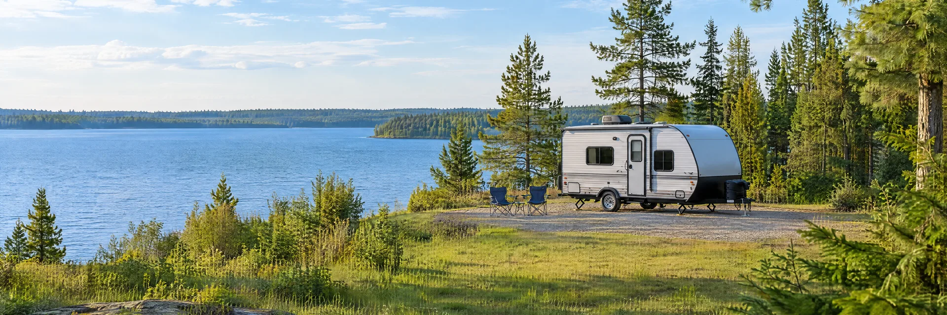 Illustration of a compact travel trailer at a fictional camping setting inspired by Hillman, MI.