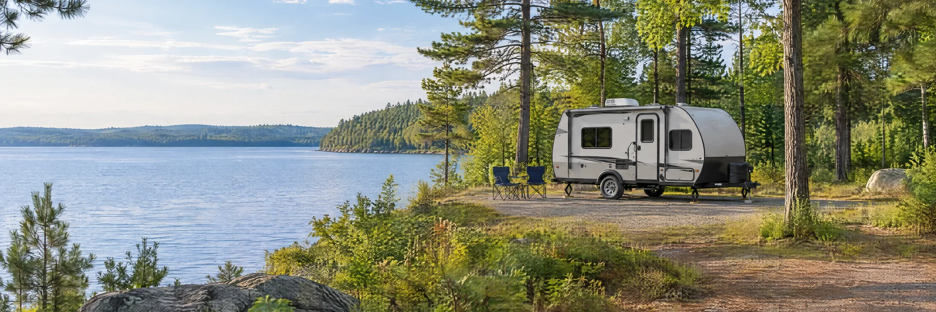 Illustration of a compact travel trailer at a fictional camping setting inspired by Irons, MI.