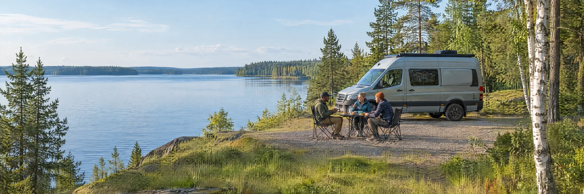 Illustration of campers enjoying an outdoor meal beside a camper van in a fictional camping setting inspired by Park Rapids, MN.