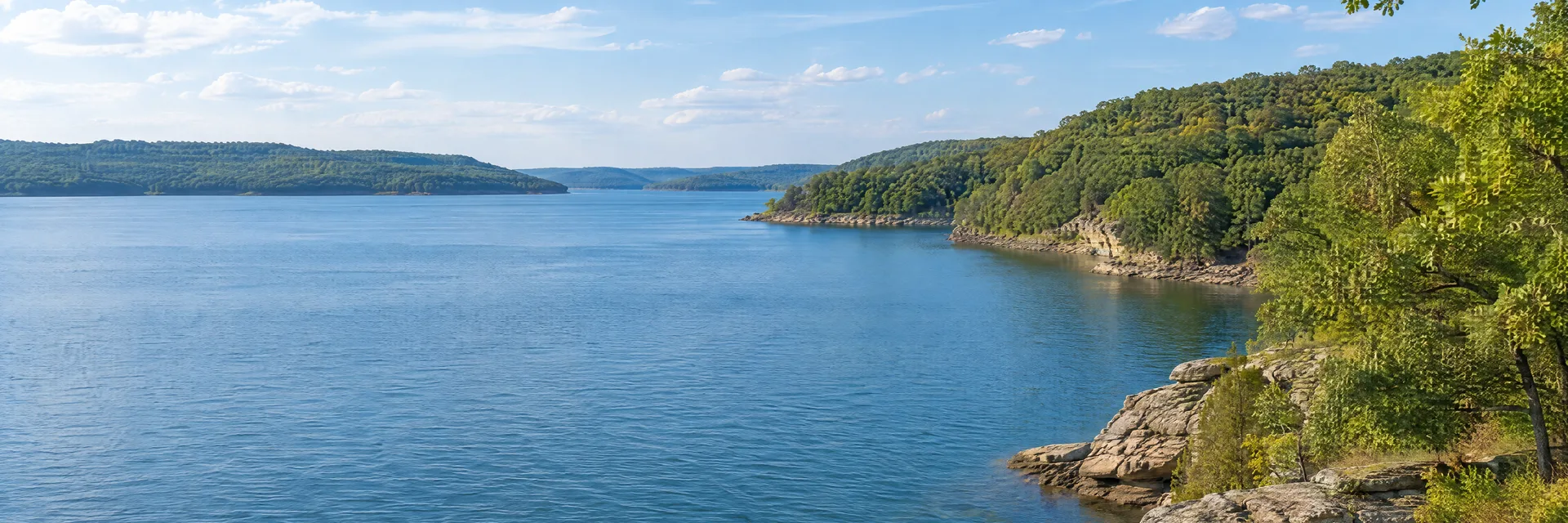 Illustration inspired by Wheatland, MO: western Missouri reservoir country, broad blue freshwater lake, wooded oak-covered slopes and quiet rocky shoreline.