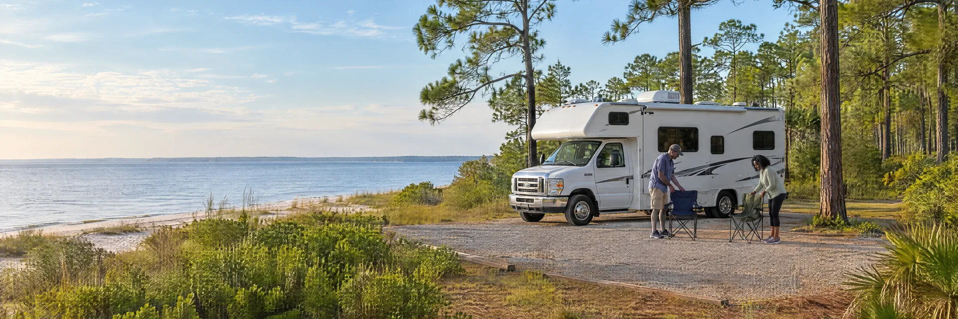 Illustration of campers enjoying setting up camp beside a Class C motorhome in a fictional camping setting inspired by Biloxi, MS.