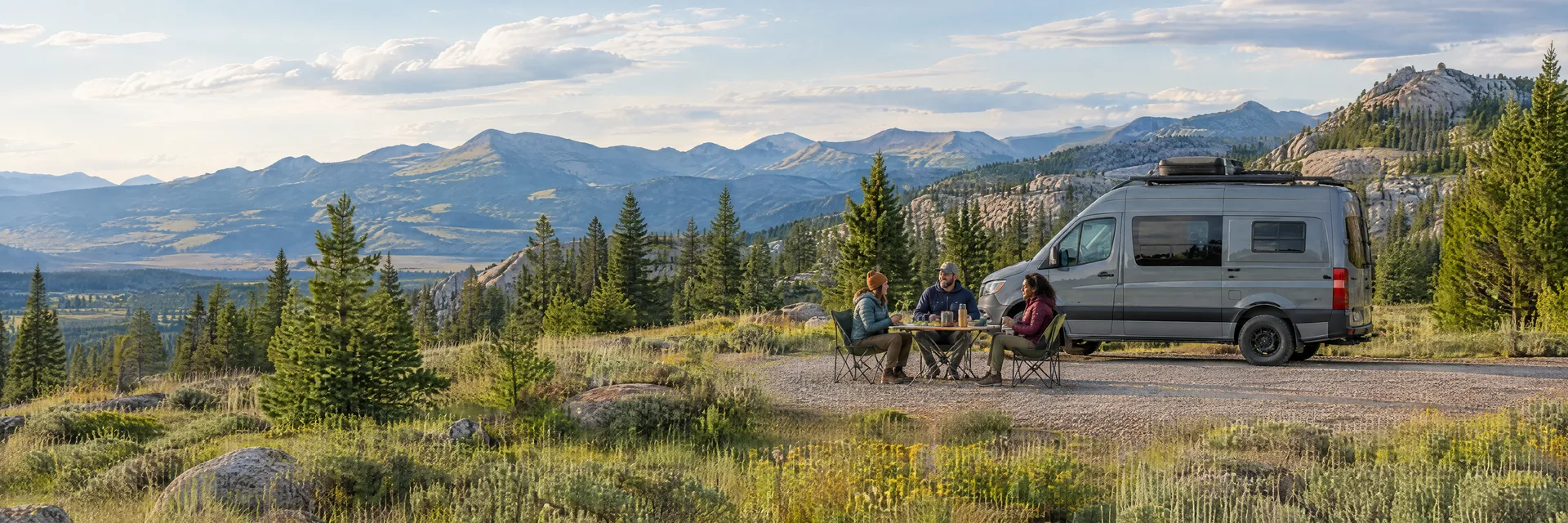 Illustration of campers enjoying an outdoor meal beside a camper van in a fictional camping setting inspired by Butte, MT.