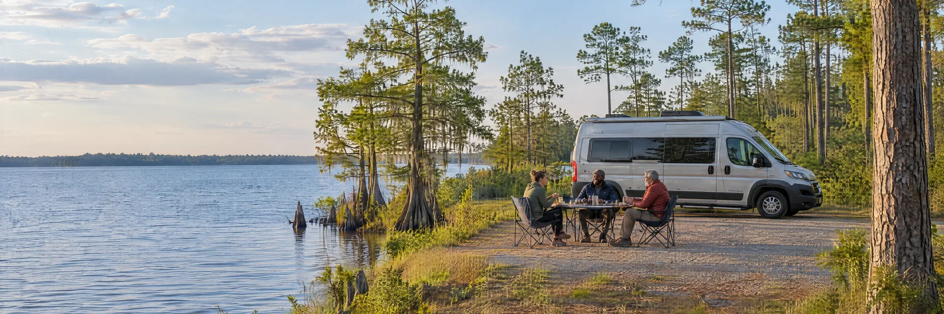 Illustration of campers enjoying an outdoor meal beside a camper van in a fictional camping setting inspired by Lake Waccamaw, NC.