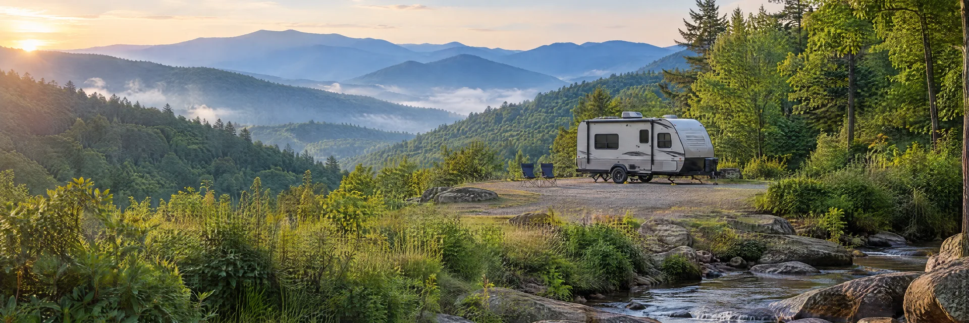 Illustration of a compact travel trailer at a fictional camping setting inspired by Robbinsville, NC.
