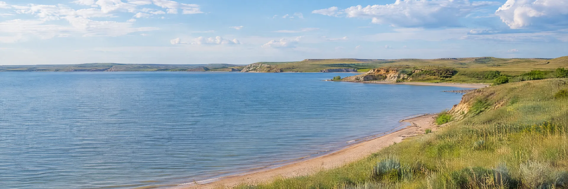 Illustration inspired by Ogallala, NE: western Nebraska prairie lake, sandy shoreline and gentle grass-covered slopes.