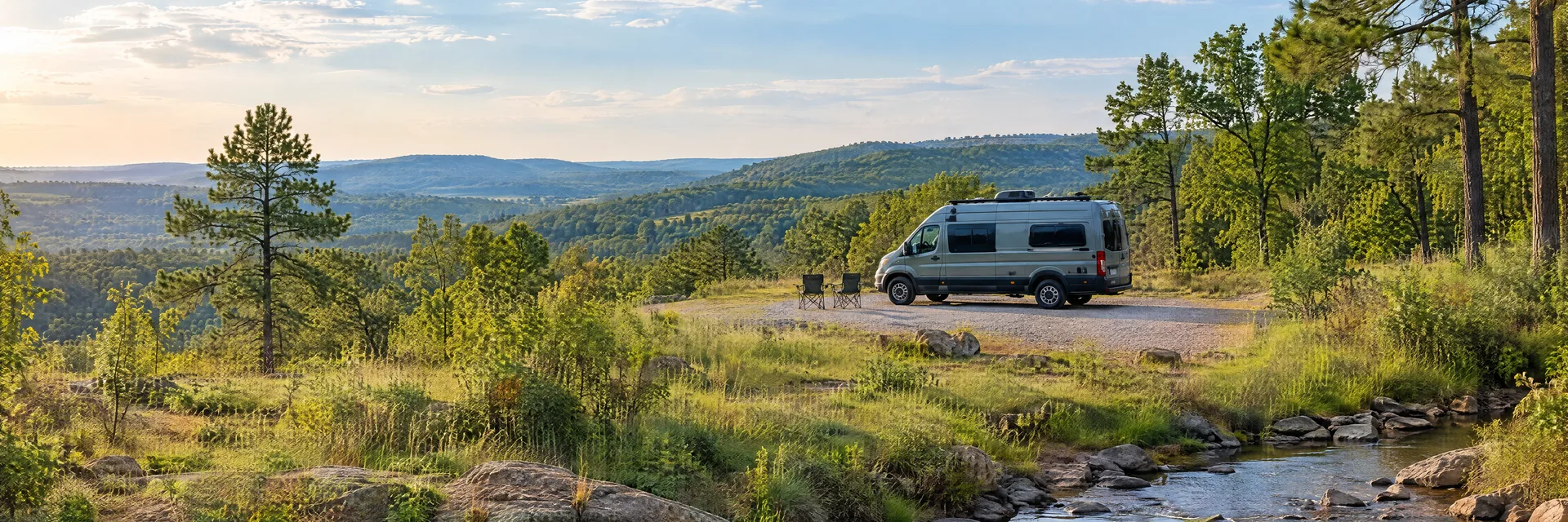 Illustration of a camper van at a fictional camping setting inspired by Antlers, OK.