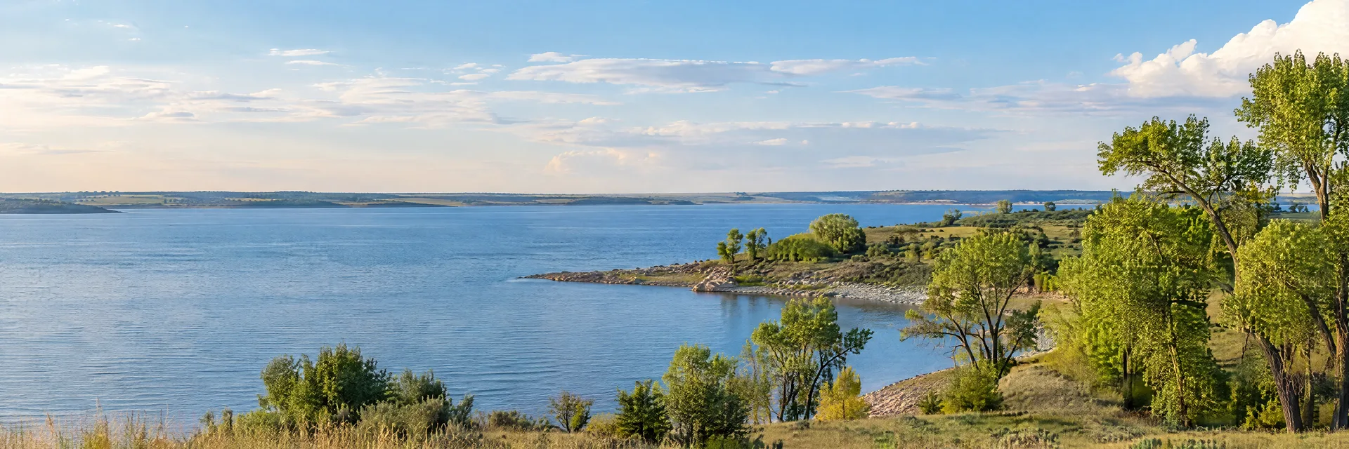 Illustration inspired by Ponca City, OK: northern Oklahoma reservoir shore, prairie grasses and scattered cottonwoods.