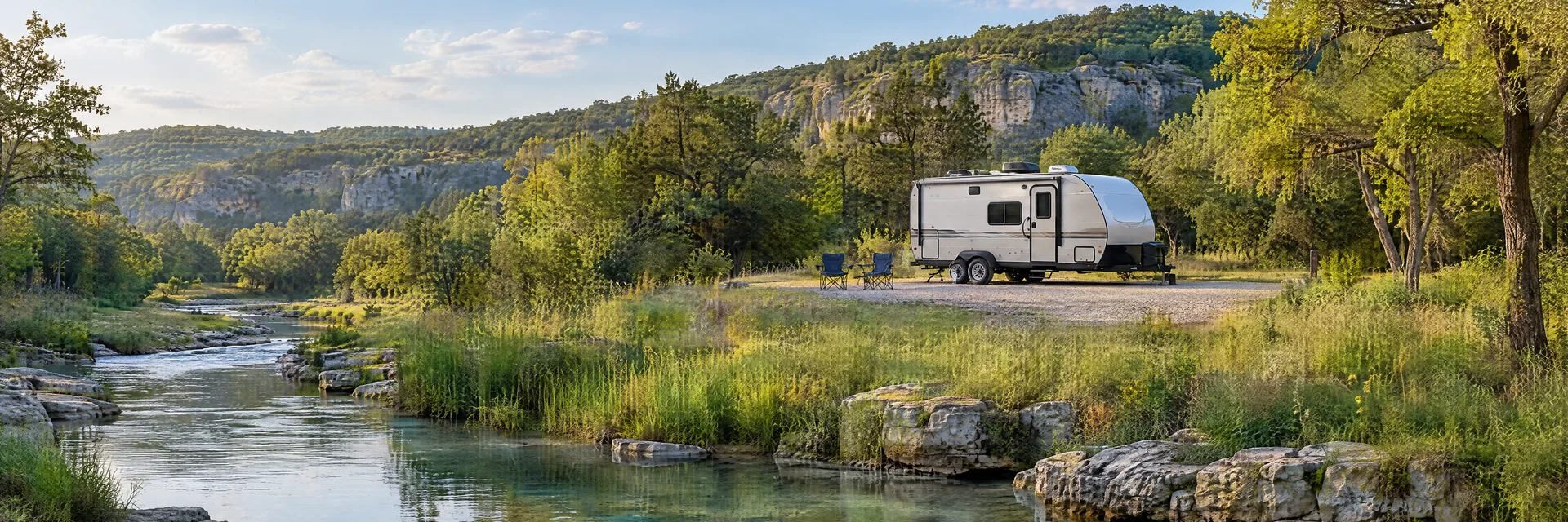 Illustration of a compact travel trailer at a fictional camping setting inspired by Sulphur, OK.