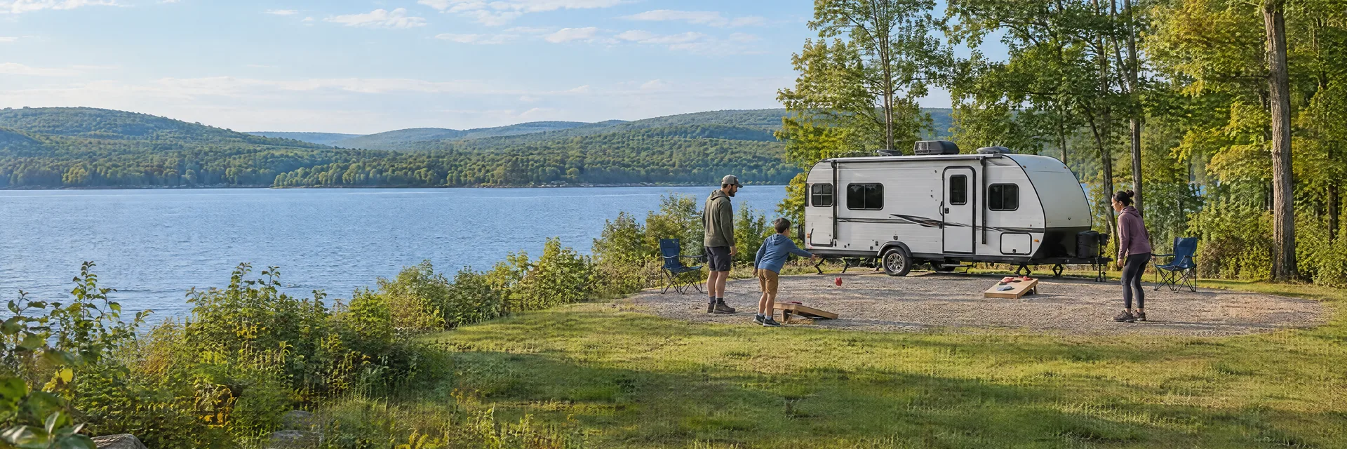 Illustration of campers enjoying family campsite activities beside a compact travel trailer in a fictional camping setting inspired by JAMESTOWN, PA.
