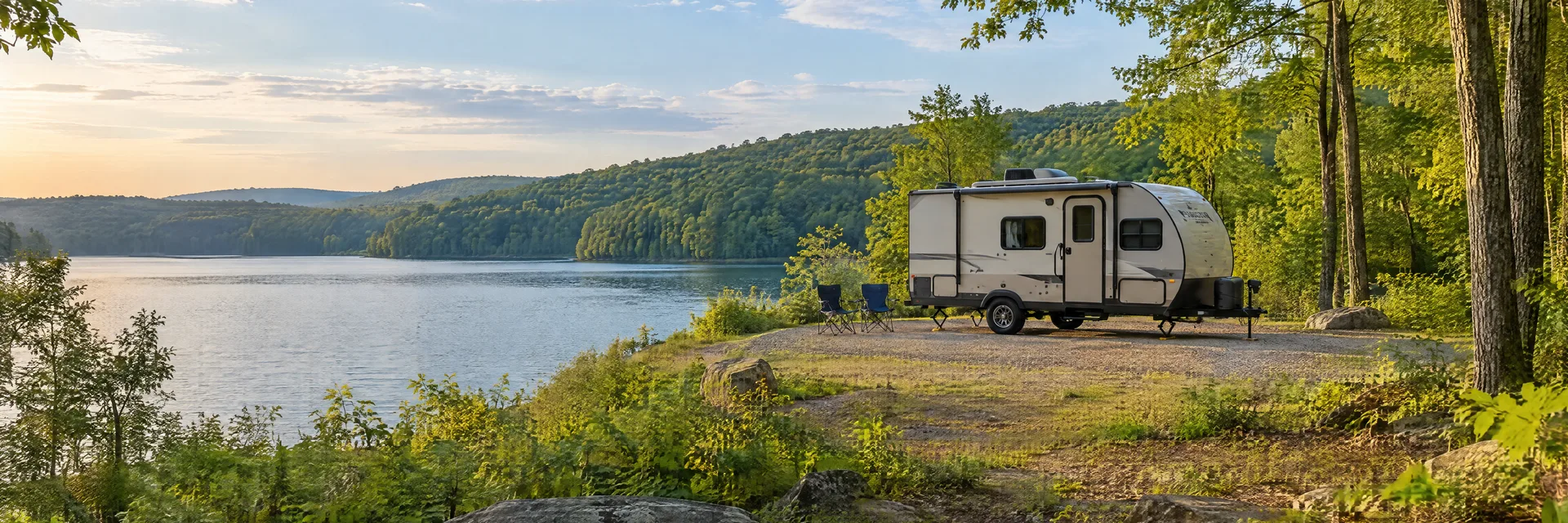 Illustration of a compact travel trailer at a fictional camping setting inspired by SANDY LAKE, PA.