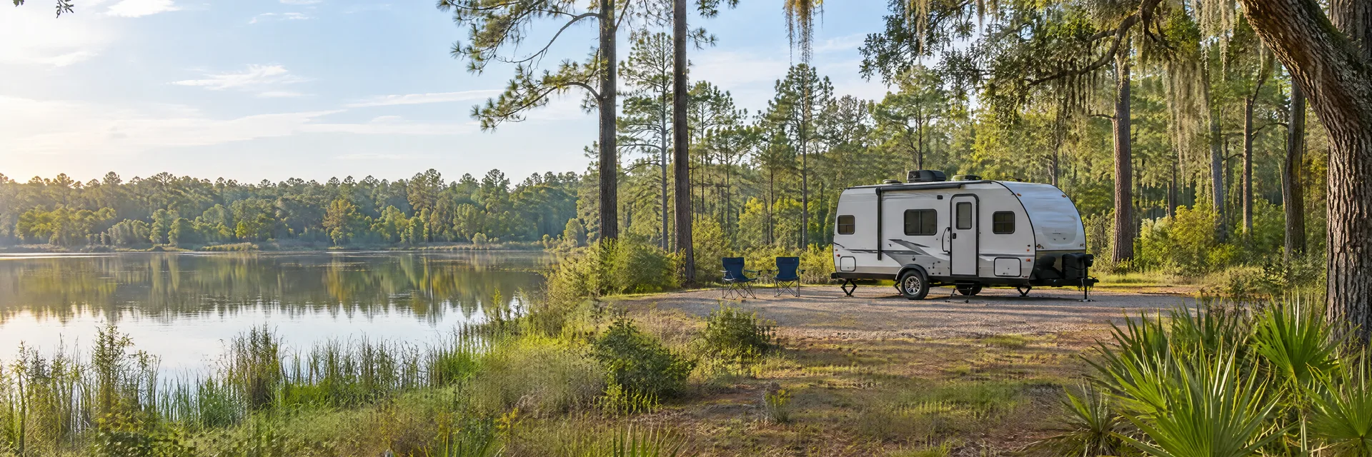 Illustration of a compact travel trailer at a fictional camping setting inspired by Ladson, SC.