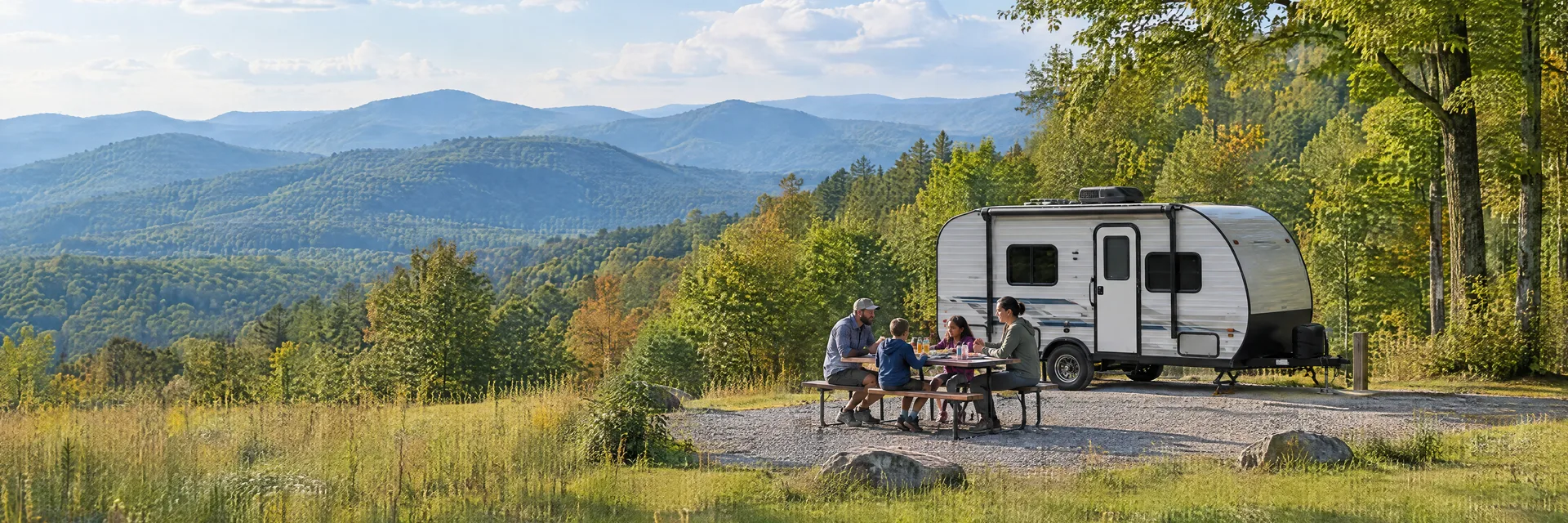 Illustration of campers enjoying a family picnic beside a compact travel trailer in a fictional camping setting inspired by Travelers Rest, SC.