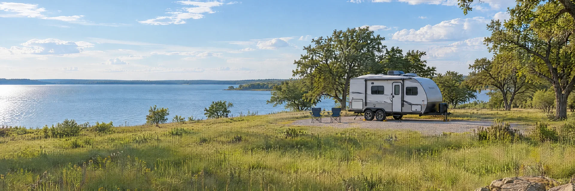 Illustration of a compact travel trailer at a fictional camping setting inspired by Alvarado, TX.