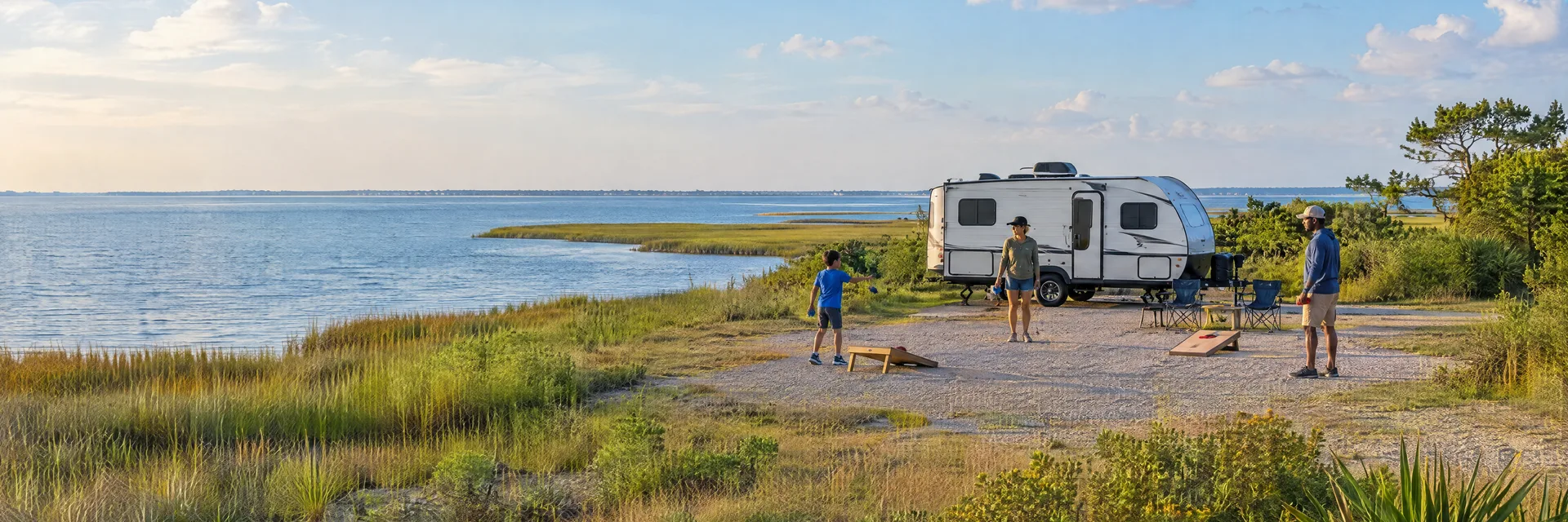 Illustration of campers enjoying family campsite activities beside a compact travel trailer in a fictional camping setting inspired by Aransas Pass, TX.