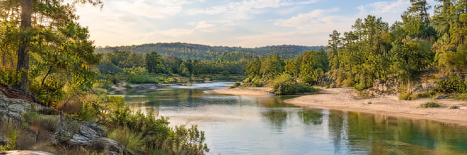 Illustration inspired by Bastrop, TX: central Texas pine-oak river corridor with sandy banks and warm light.
