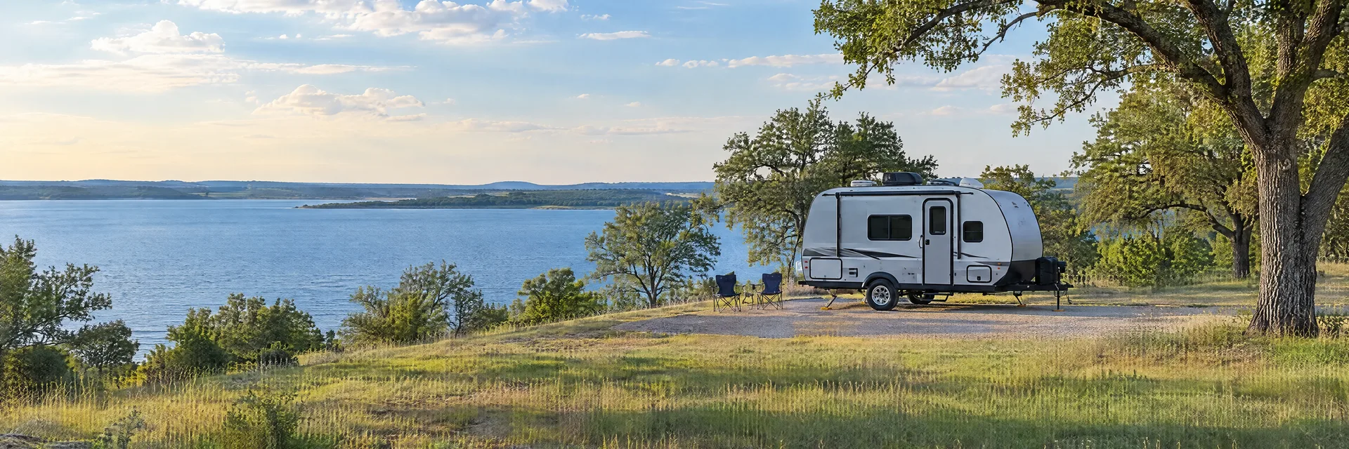 Illustration of a compact travel trailer at a fictional camping setting inspired by Corsicana, TX.