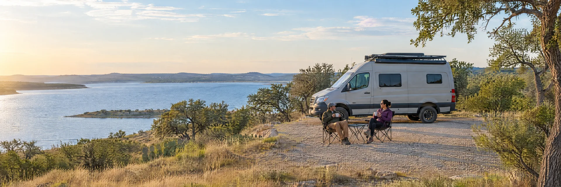 Illustration of campers enjoying morning coffee beside a camper van in a fictional camping setting inspired by MATHIS, TX.