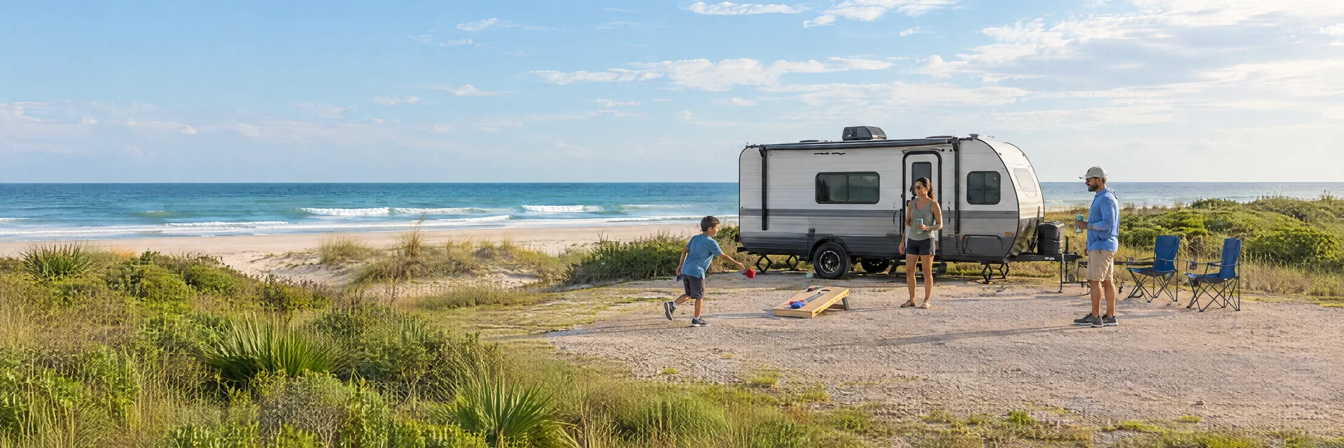 Illustration of campers enjoying family campsite activities beside a compact travel trailer in a fictional camping setting inspired by Surfside Beach, TX.