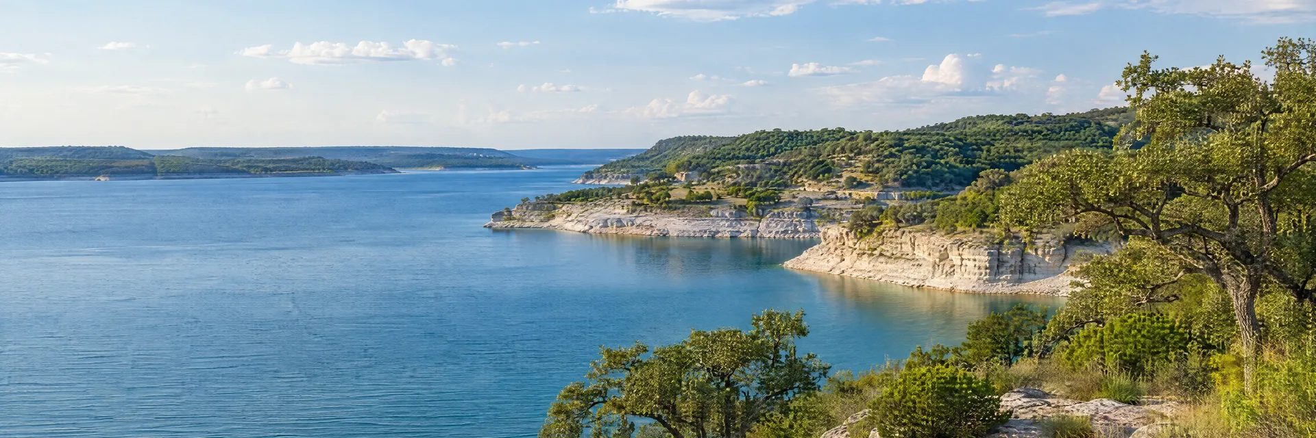 Illustration inspired by WHITNEY, TX: lake Whitney-inspired blue reservoir with pale limestone banks and oak woods.