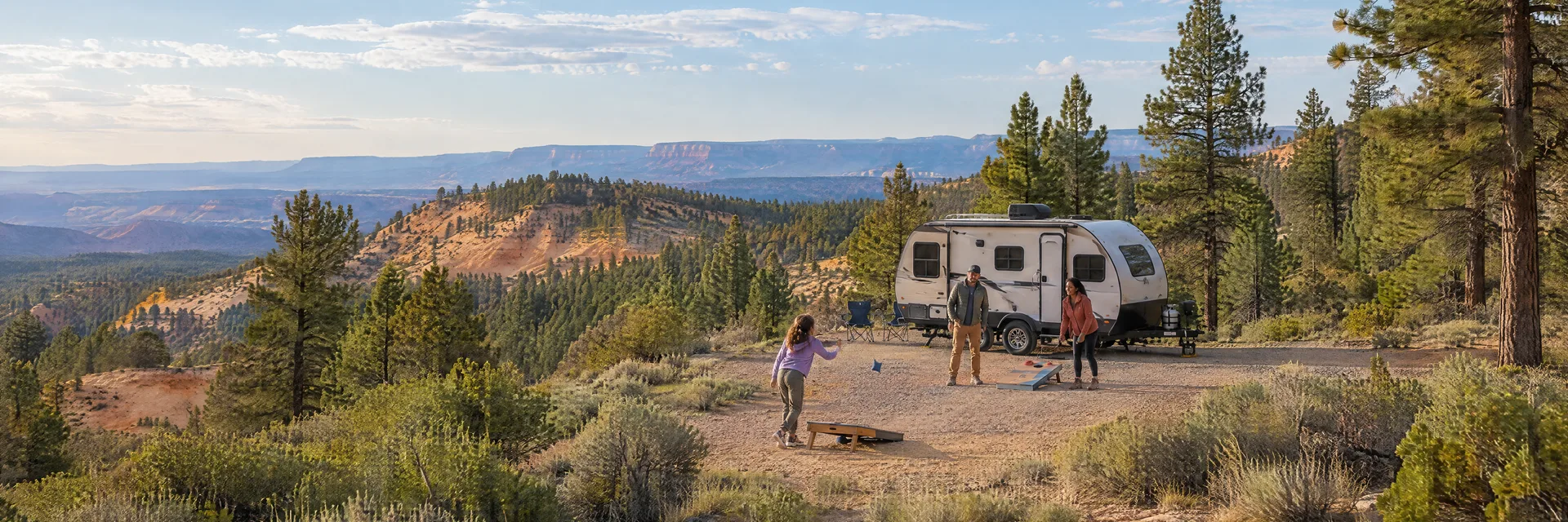 Illustration of campers enjoying family campsite activities beside a compact travel trailer in a fictional camping setting inspired by Bryce, UT.