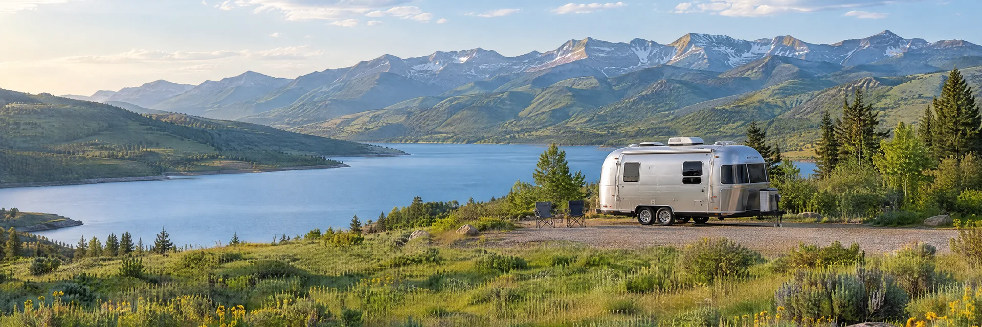 Illustration of a rounded silver travel trailer at a fictional camping setting inspired by Heber City, UT.