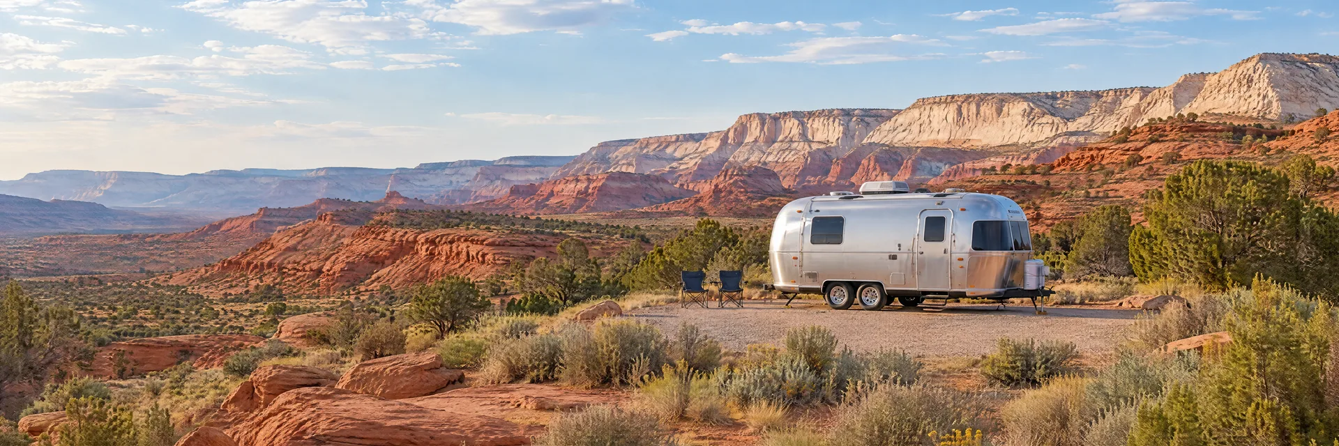 Illustration of a rounded silver travel trailer at a fictional camping setting inspired by St. George, UT.