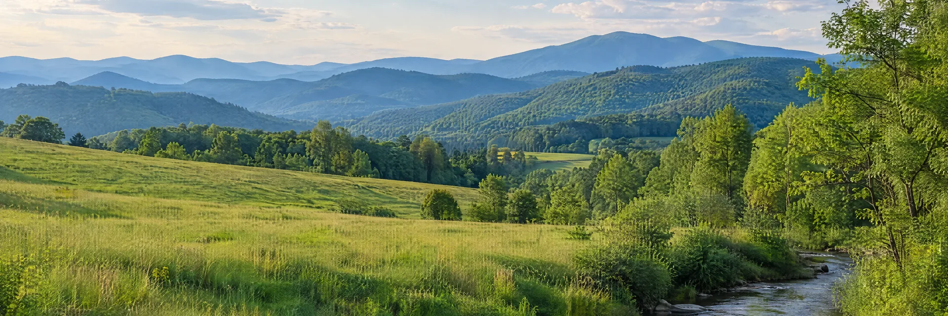 Illustration inspired by Blacksburg, VA: southwestern Virginia Appalachian countryside, rolling green pasture, leafy creek and layered forested mountain ridges.