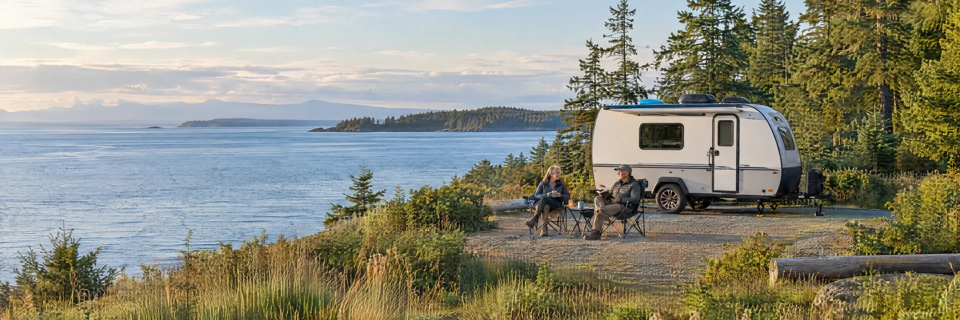 Illustration of campers enjoying relaxing at camp beside a compact travel trailer in a fictional camping setting inspired by Blaine, WA.