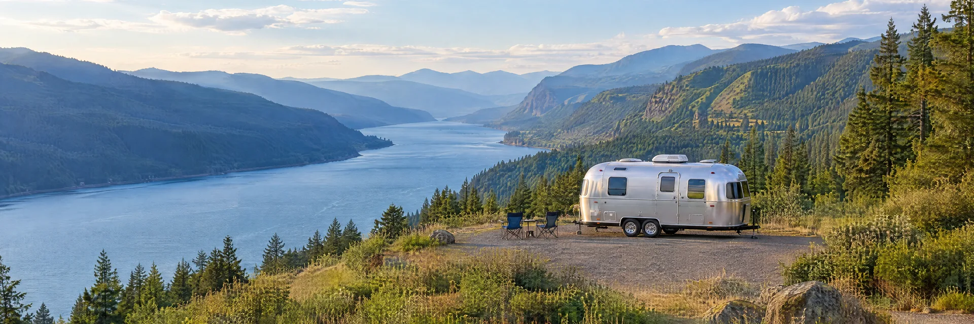 Illustration of a rounded silver travel trailer at a fictional camping setting inspired by Home Valley, WA.